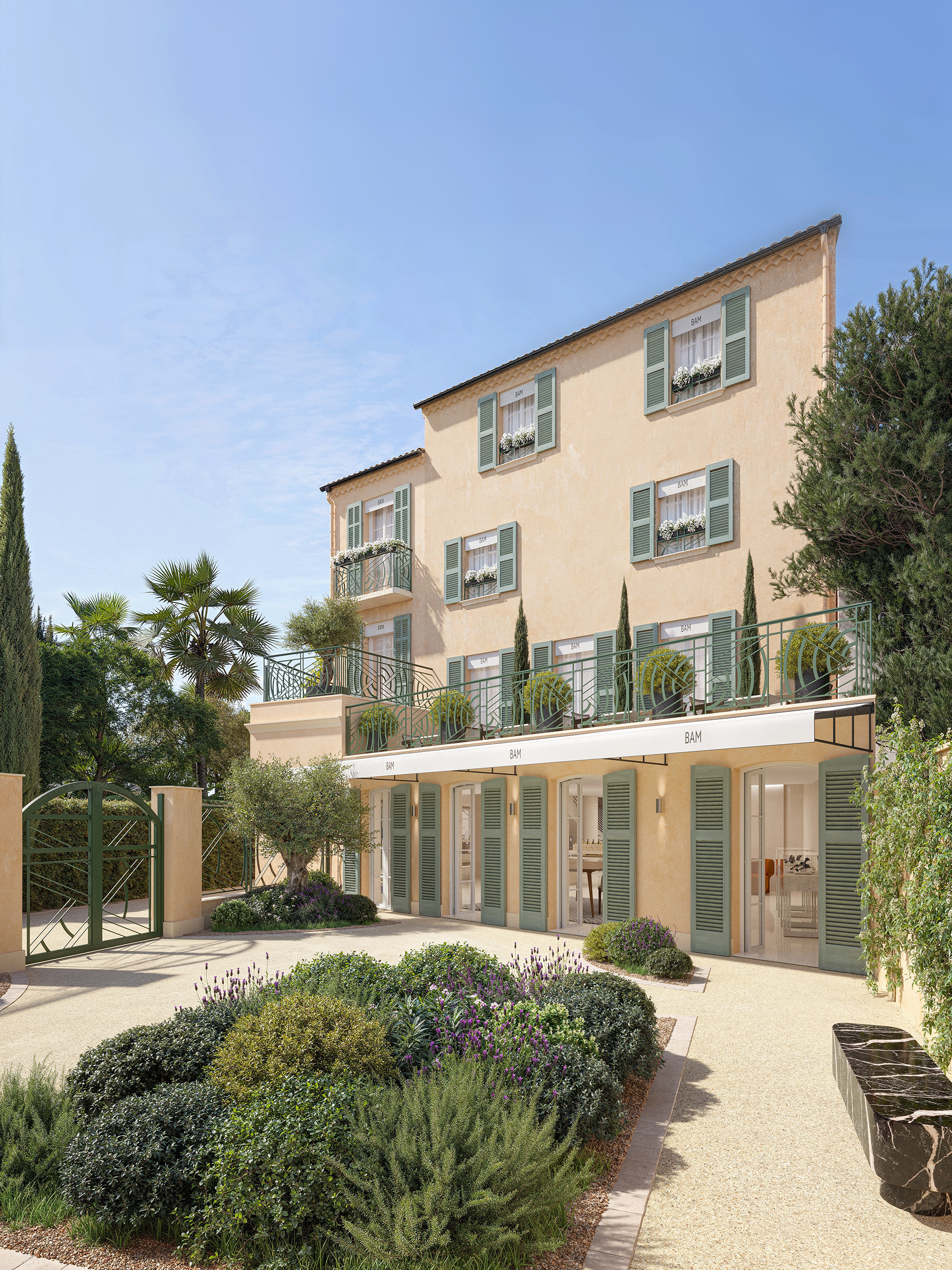 Façade sur cour de la boutique de luxe à Saint-Tropez – enduit ocre, persiennes vert sauge, jardin provençal avec lavande et oliviers