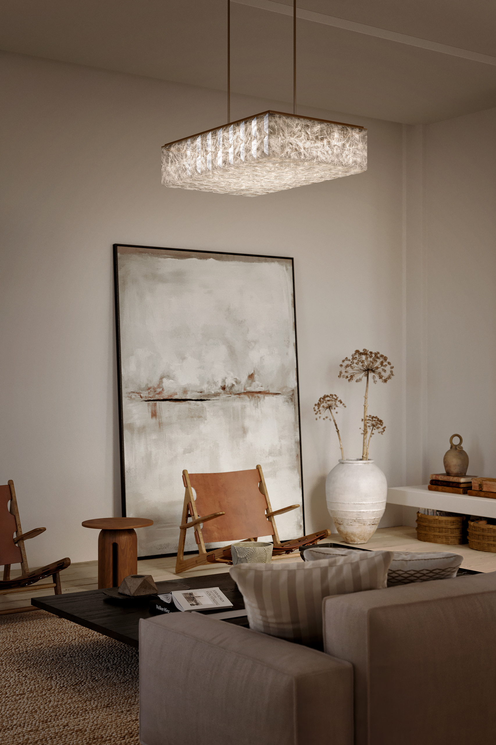 Salon minimaliste aux matières naturelles avec lustre rectangulaire en albâtre, fauteuil en cognac, vase céramique blanc et tableau abstrait.