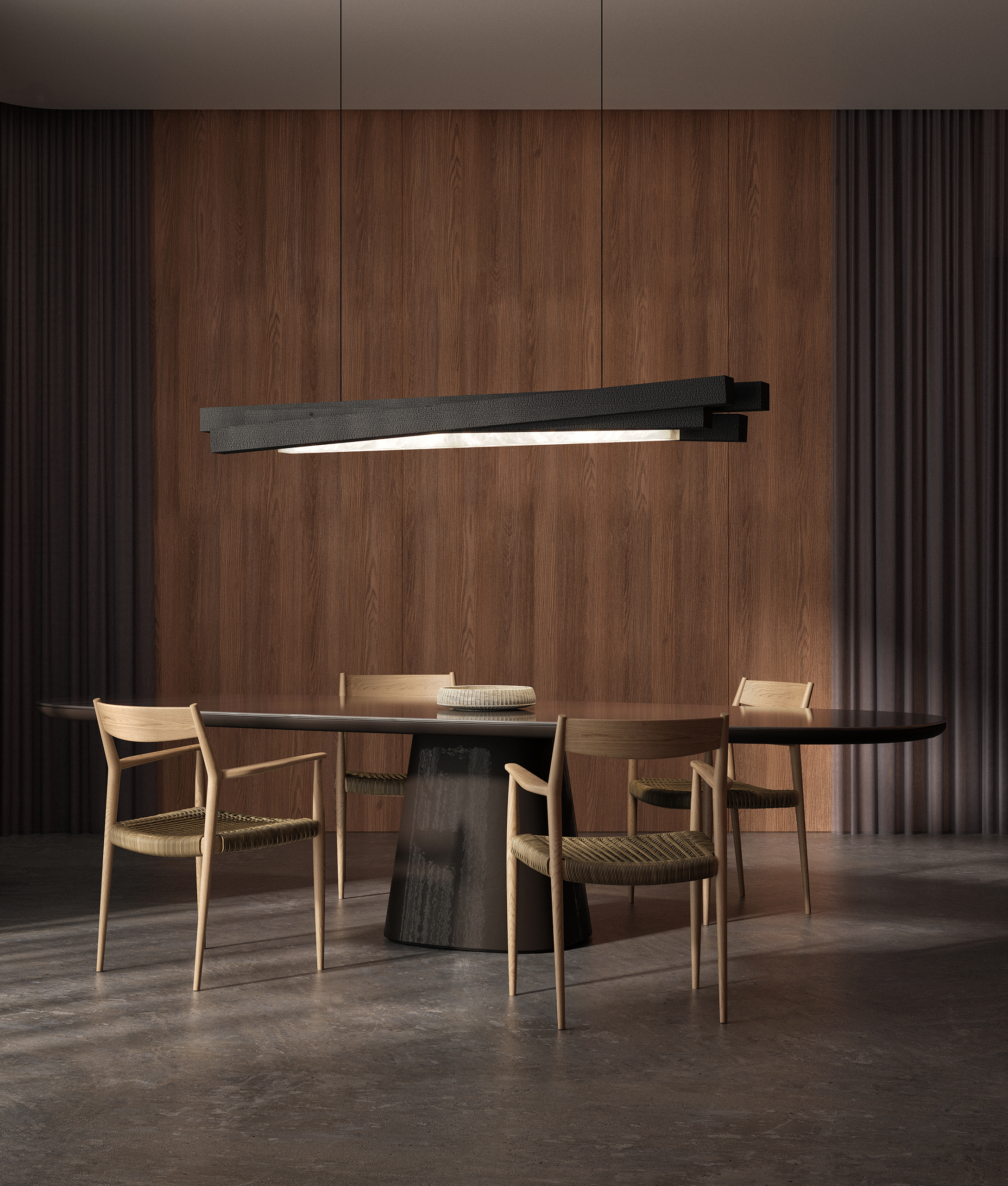 Suspension linéaire Incandescence en albâtre et bois brûlé au-dessus d'une table à piètement tronc noir.