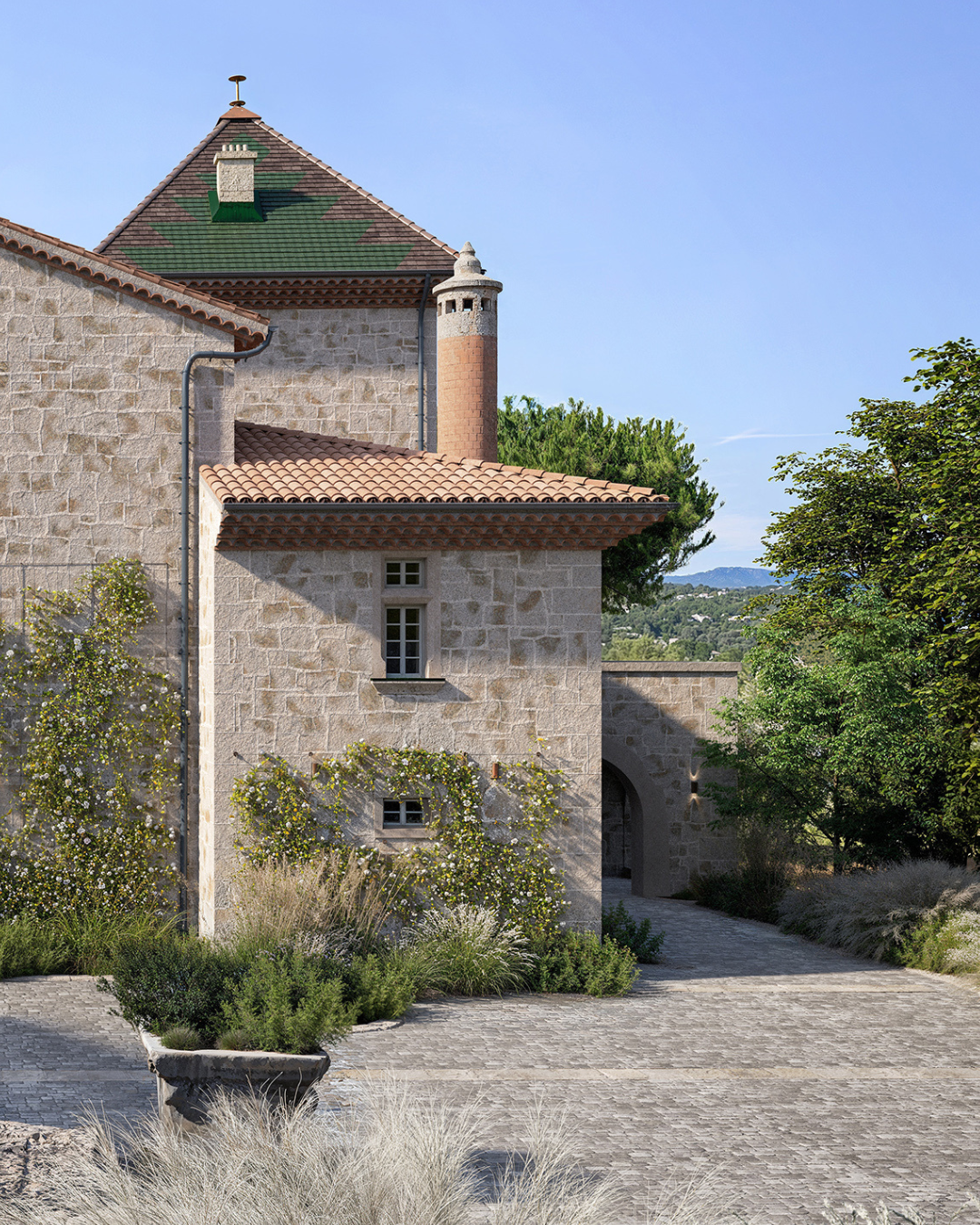 Château de La Baume en Ardèche – façade en pierre de taille, tourelle en brique, toiture en tuiles canal et cour pavée paysagère