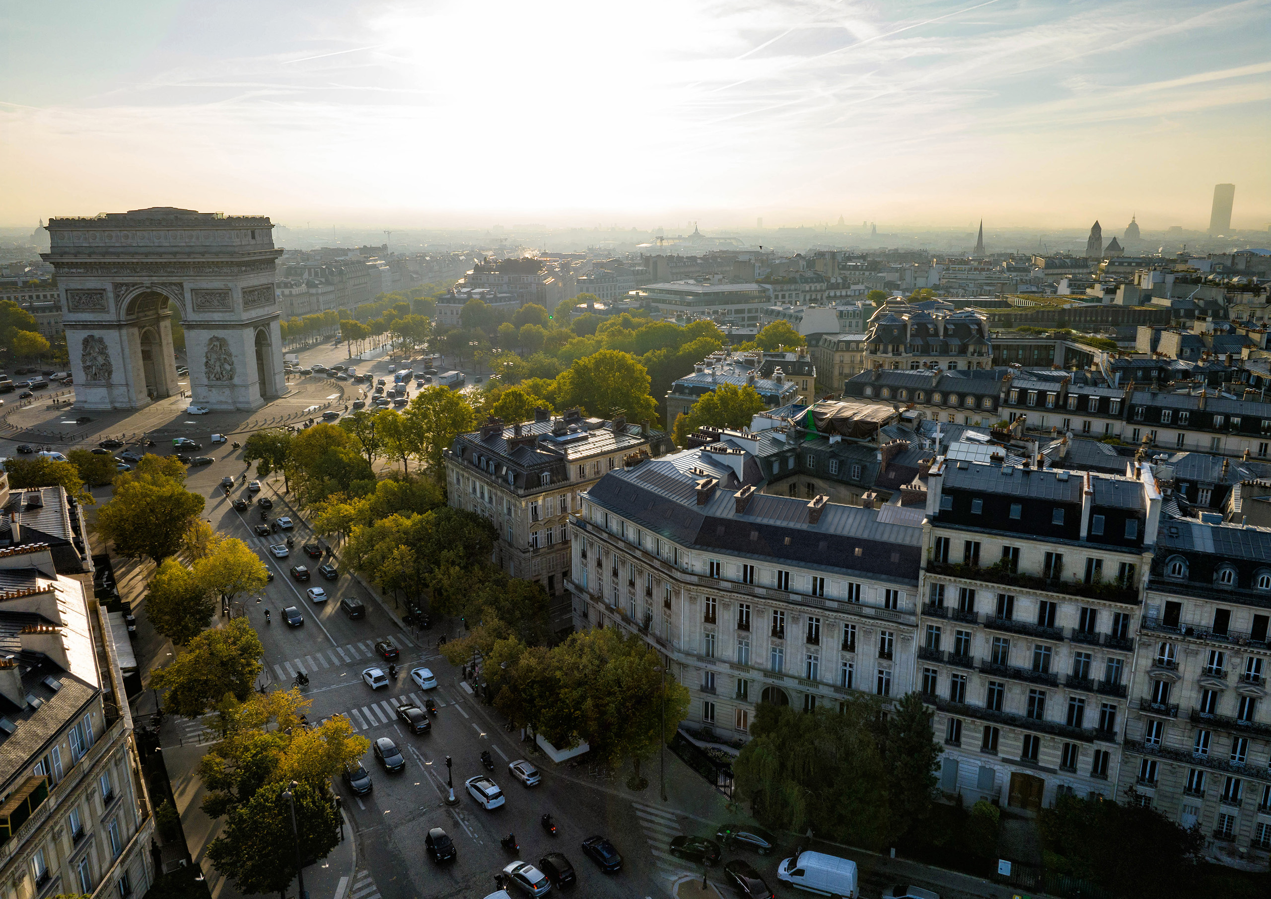 Vue aérienne du projet Précellence face à l'Arc de Triomphe, avenue Foch Paris 16e – immeuble haussmannien en angle au coucher de soleil