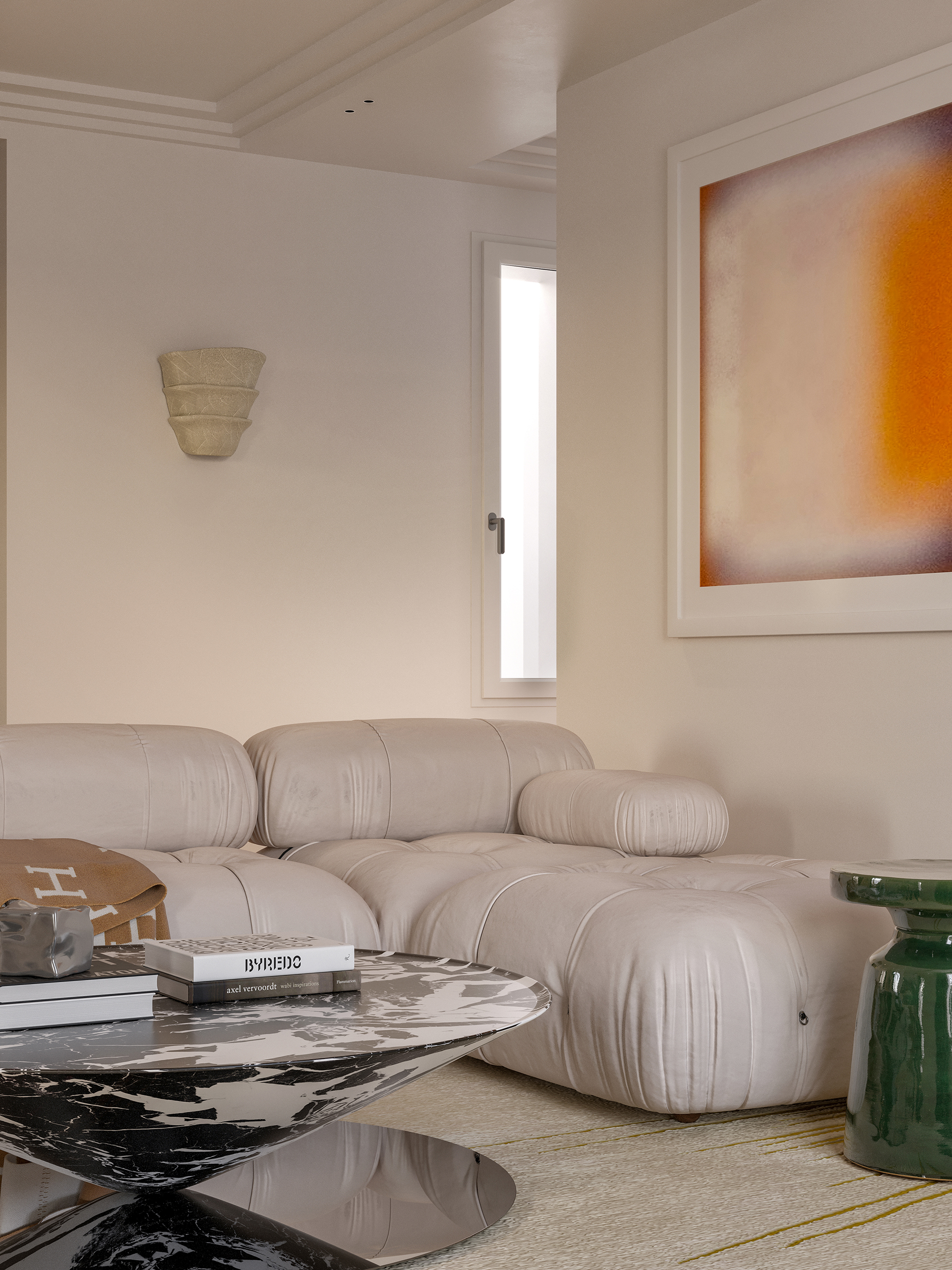 Détail salon Signature – canapé Camaleonda ivoire, table basse en marbre noir, applique en pierre sculptée et œuvre abstraite orange