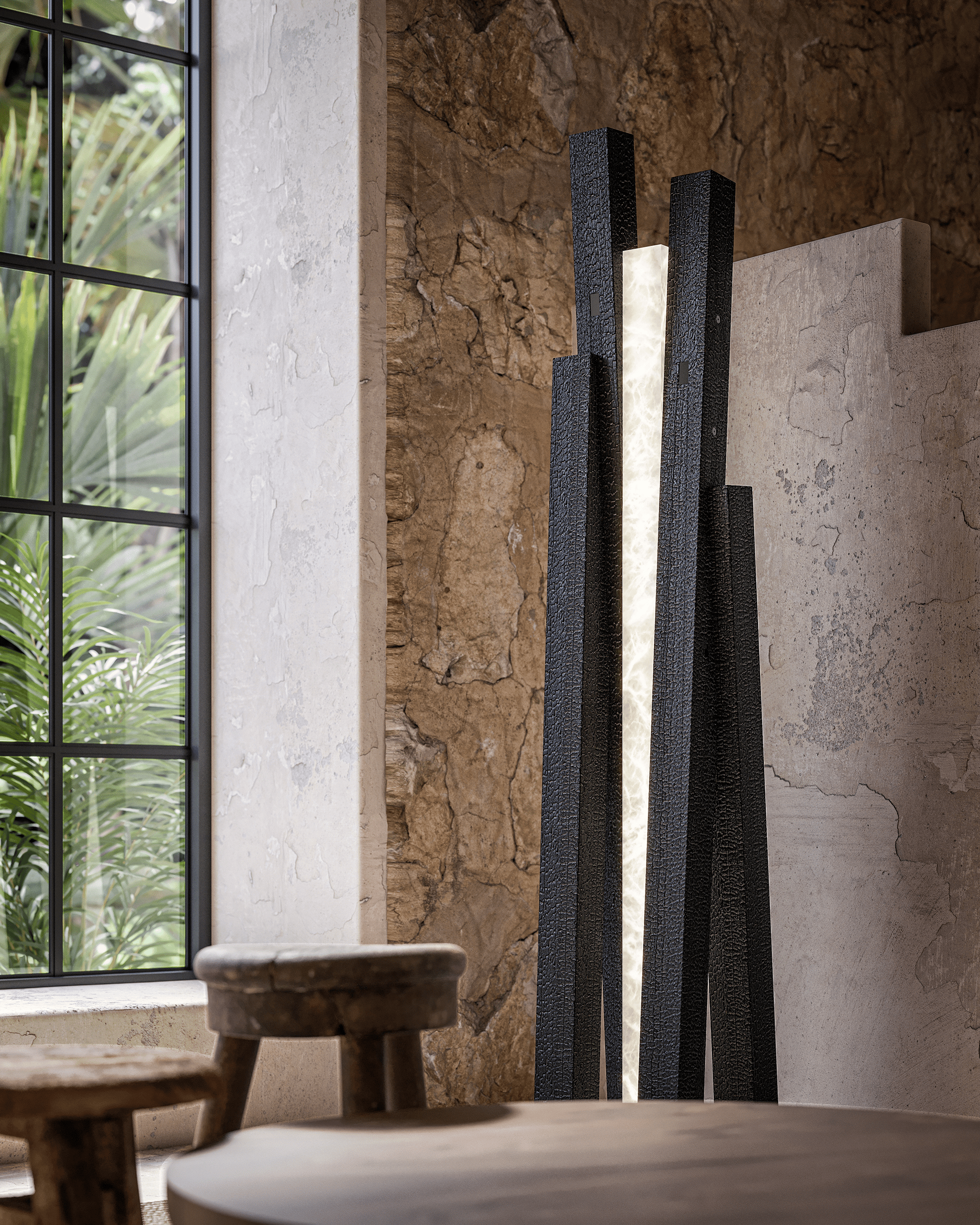 Lampadaire Incandescence Terra en lave noire texturée, fente lumineuse centrale, devant un mur en pierre brute et fenêtre sur végétation tropicale