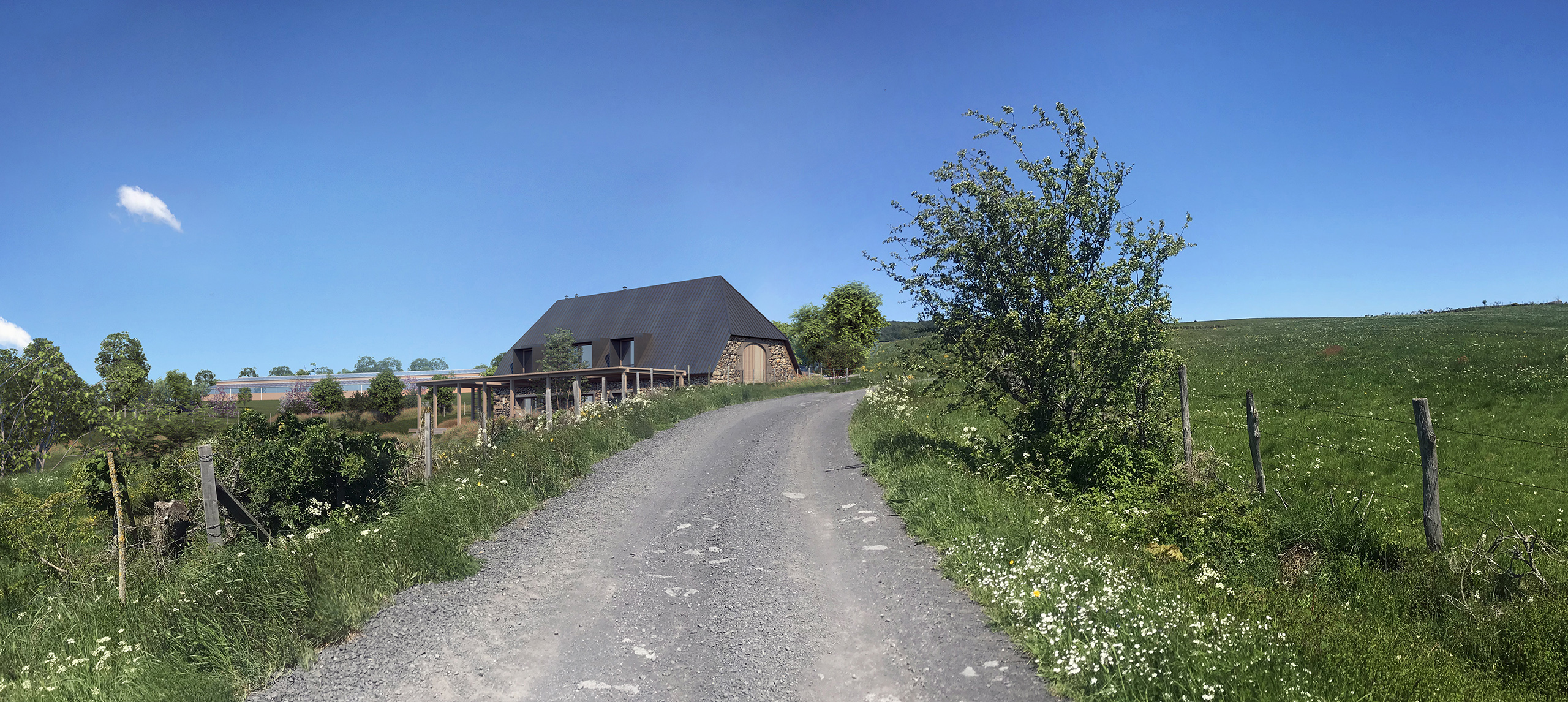 Valat – bâtisse en pierre et toiture métallique sombre au bout d'un chemin de gravier, prairies verdoyantes, ciel bleu estival